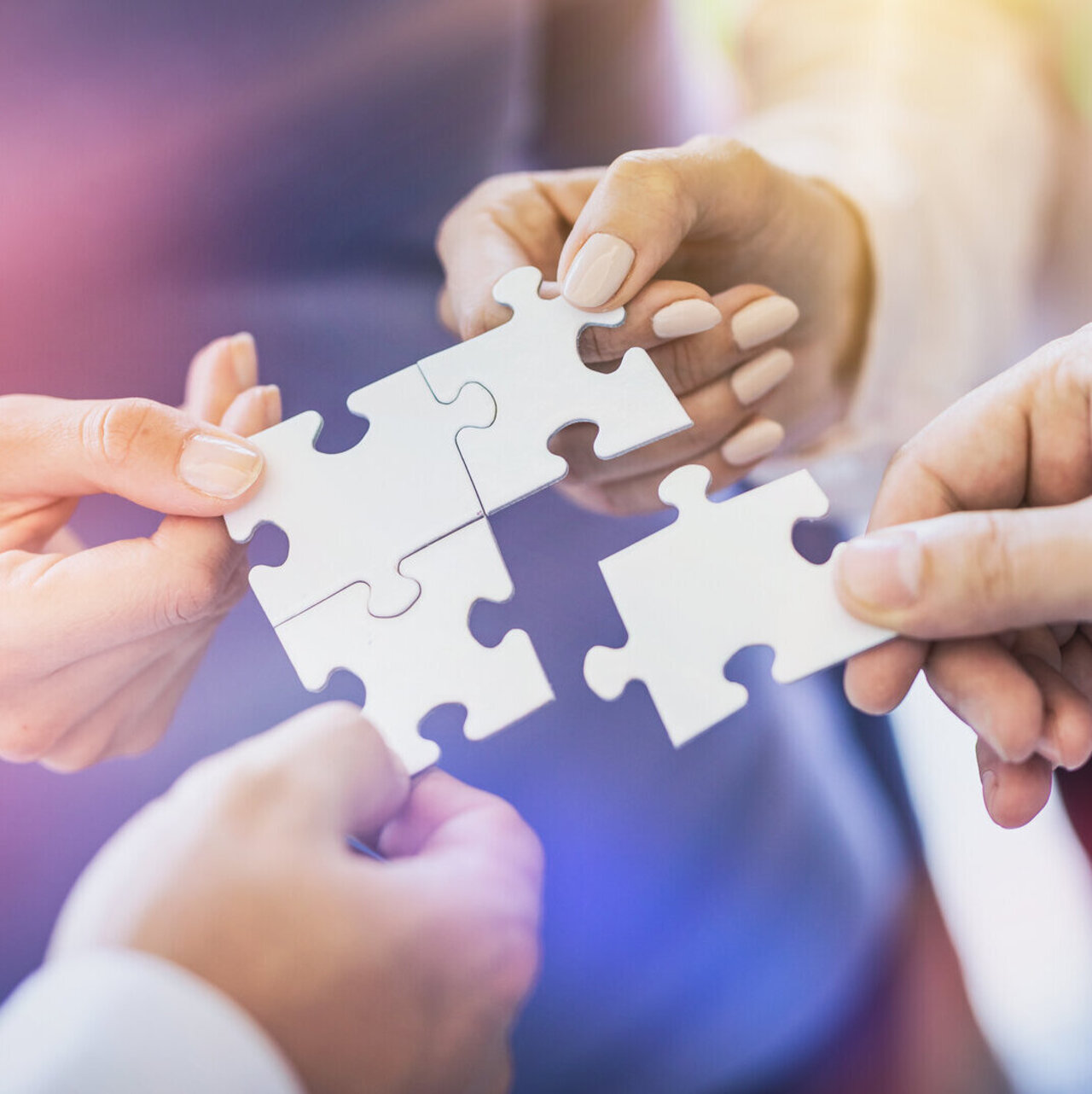 A group of business people assembling jigsaw puzzle. The concept of cooperation, teamwork, help and support in business.